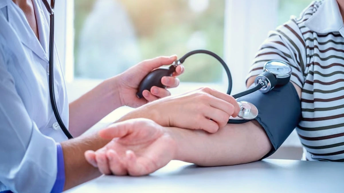 a doctor measuring a patient's blood pressure using a sphygmomanometer,